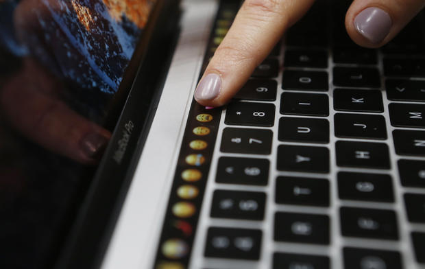 A guest points to a new MacBook Pro during an Apple media event in Cupertino, California, U.S. October 27, 2016. REUTERS/Beck Diefenbach - RTX2QRFM